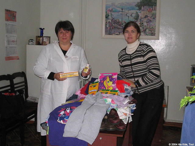 His Kids, Too! director and facility director poise with some of the donations.
