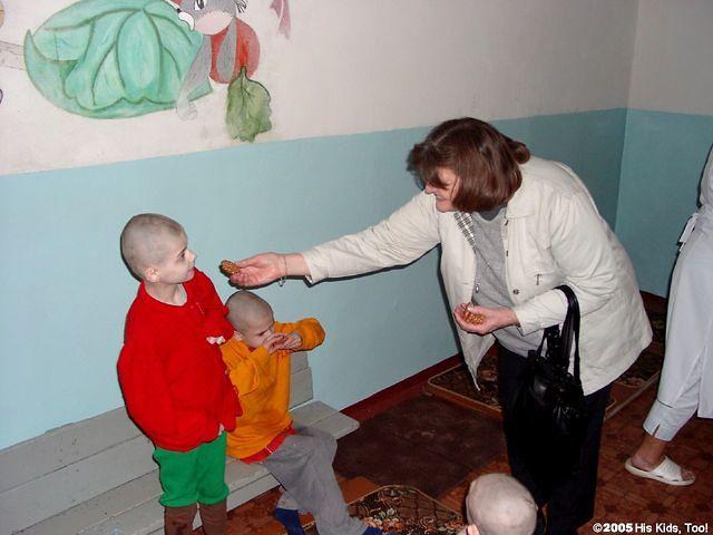 Lynn gives cookies to a child.