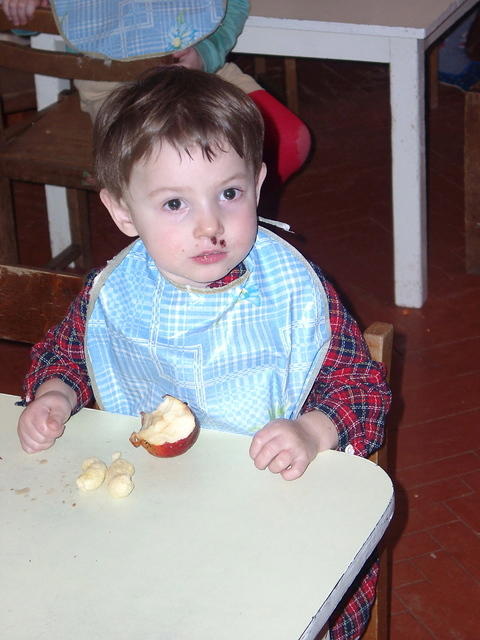 This little one enjoys his apple.