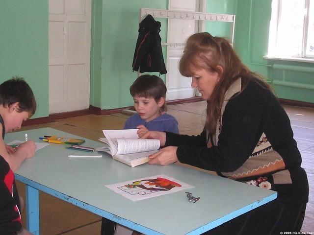 One of the teachers assist one child to find the right place.