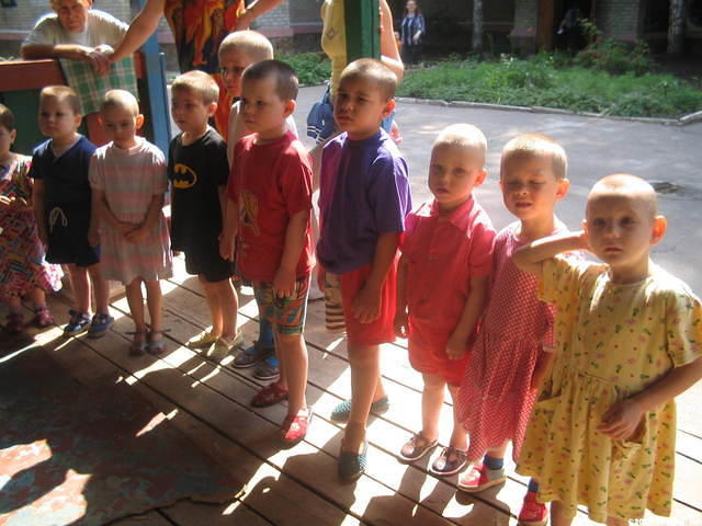 The smallest children wait patiently for clothing.