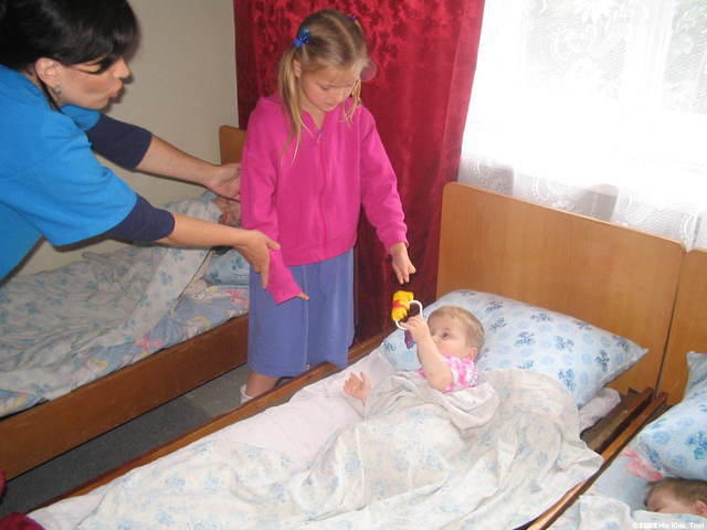 Alla, hands this little girl a new toy.