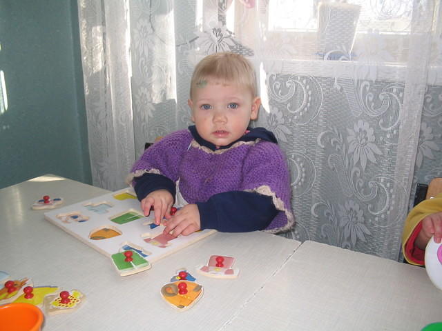 This little girl works with a puzzle with adaptive knobs.