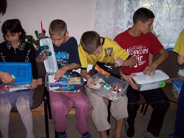 The children carefully look in their gifts.