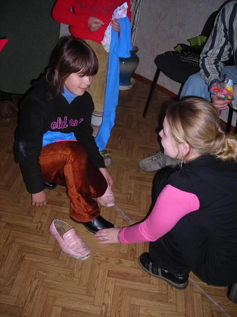 Sundy fits shoes on one little girl.