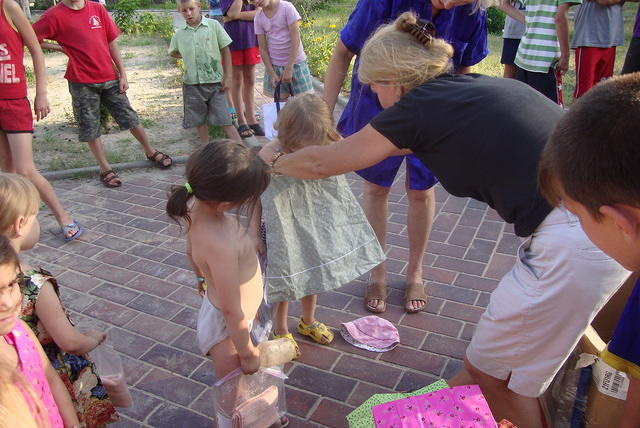 Teresa fitting a girl with a new dress.