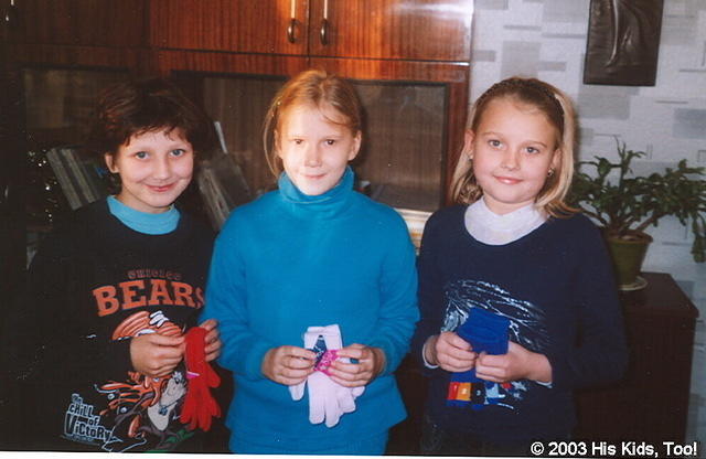 These young ladies are wearing their new clothing, and holding some gifts.