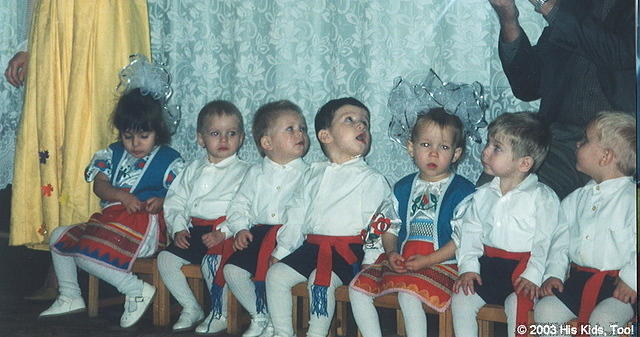 The children carefully listen to their teacher giving instructions.