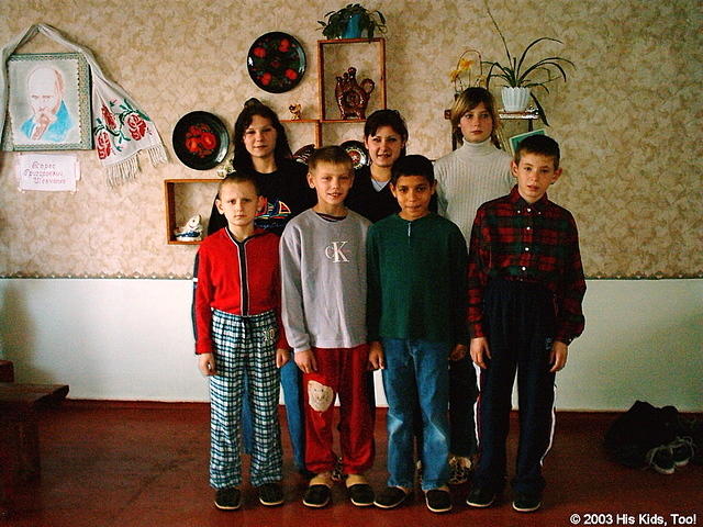 These orphans stand in front of their 'Red Corner', they are wearing their new slipper and clothing, thank you for your donation
