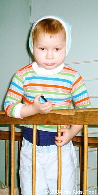 This little boy is sad that they won't let him out of this crib.