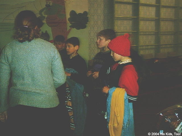 Boys wait patiently while volunteers pass out clothing and personal care products.