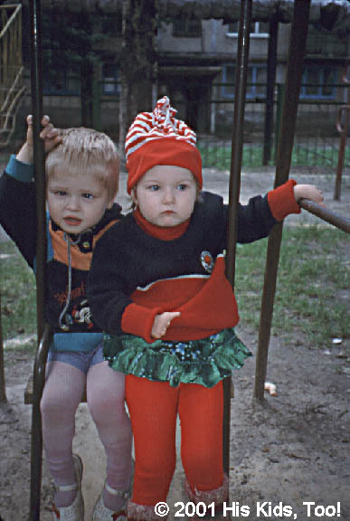 This beautiful girl and boy, though dressed for winter in mid summer, love to swing together!