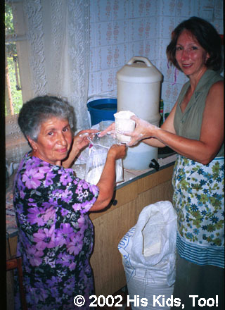His Kids, Too! Board member, Faye W. and local church member Leza help bag food for widow food bags.