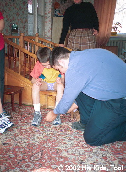 Dallas works on fitting shoes on children.