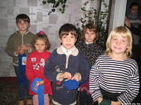 These little girls, wearing their new clothing, are happy to receive their new warm stockings.