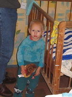 This little boy keeps a careful watch over his little baby  brother (3 months old) that is sleeping in the crib.