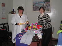 His Kids, Too! director and facility director poise with some of the donations.