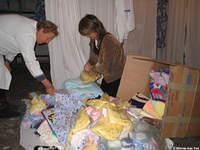 Fami unloads donations while the assistant prepares for the inventory.
