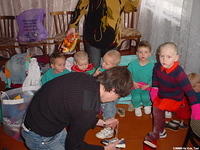 Vanya assists in putting new shoes on all the children.