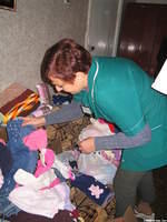 Natasha, friend, and hospital employee pulls out the clothing for the children that she cares for.