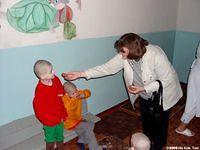 Lynn gives cookies to a child.