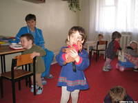 This little girl likes her toy, but they love the riding toy (foreground).