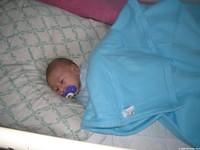 This baby rests soundly under a warm blanket.