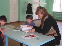 One of the teachers assist one child to find the right place.