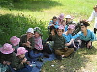 This group of boys sit in the grass, enjoying the day.