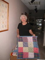 Margaret B. holds one of her many hand sewn quilts.