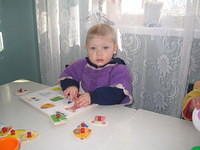 This little girl works with a puzzle with adaptive knobs.