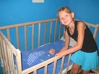 Alla carefully rocks the baby.