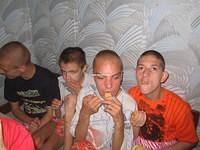 These boys eat their food anxiously.
