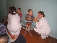 Nikka gives this young boy the special attention he needs to eat his banana.