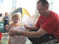 Victor,minister of both the Mayski and Kirovo Church of Christ, checks this outfit for size for this little girl.