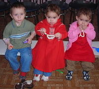 The precious twins enjoy their candy necklaces.