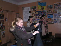 Sundy holds up clothing, allowing the girls to choose.