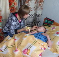 Natasha feeds this boy a banana.