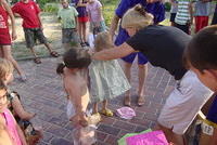 Teresa fitting a girl with a new dress.