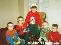 His Kids, Too! volunteer, Artur poses with 4 boys and their new toys.