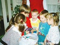 The children wait with eager anticipation of receiving their gift.
