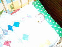 This little one lies comfortably on her new mattress with a new quilt.