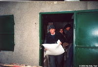 His Kids, Too! volunteer, Dima carries a bag of  flour to the car.