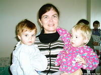 His Kids, Too! director, Teresa Fillmon  holds 2 children who reside at the home for children with Aids.