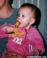 This little girl enjoys her new Pluto dog, even if she is chewing on it!