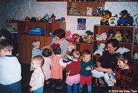 These children and orphanage staff enjoy looking at the new toys.