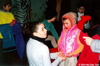 His Kids, Too! volunteer Haley, fits a jacket on this little girl while others await their turn for clothing assistance.