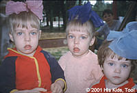 This set of twins enjoy playing with their little friend outdoors. (Update: the twins have been adopted)