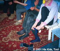 Children put on their new socks on their once bare feet.