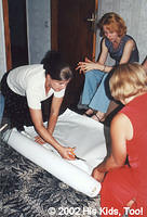 His Kids, Too! Director, cuts rubber mattress covers for baby cribs.